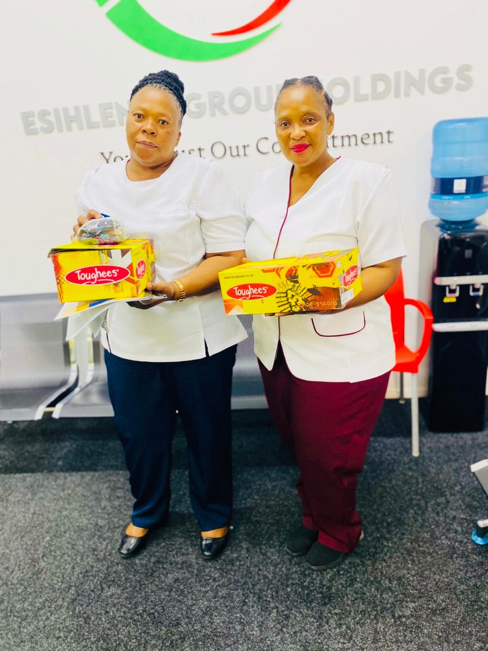Recipients holding donated school shoes at Esihlentu Group